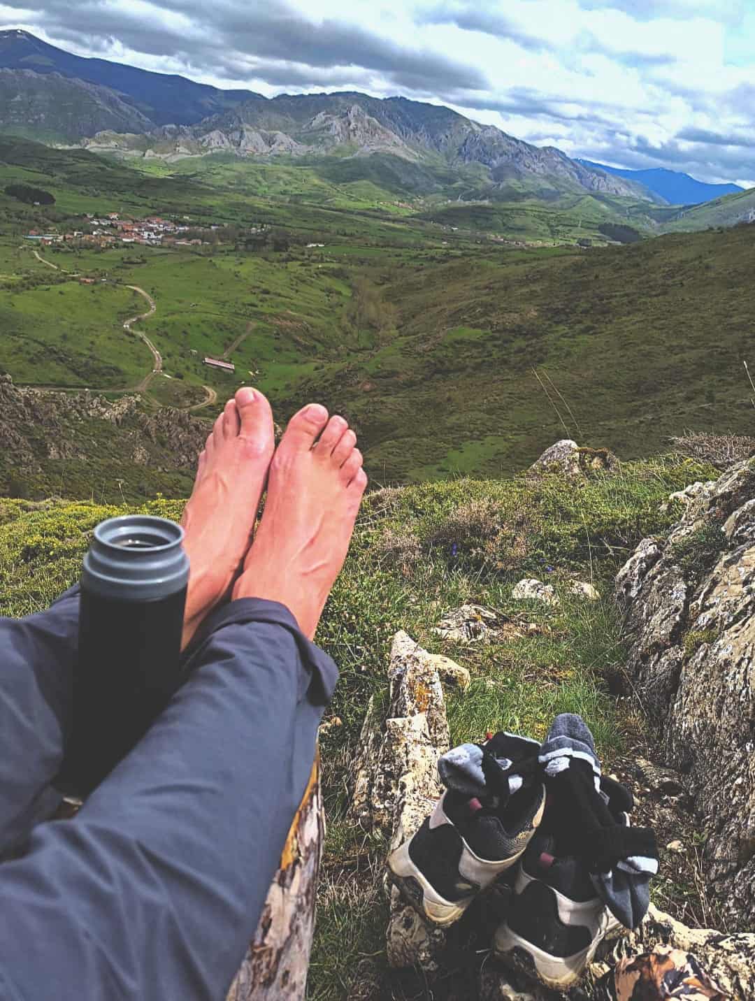 Pies descalzos en la montaña con vistas a un valle. Imagen de descanso y reflexión, símbolo del enfoque práctico del blog Revenue en Ruta.