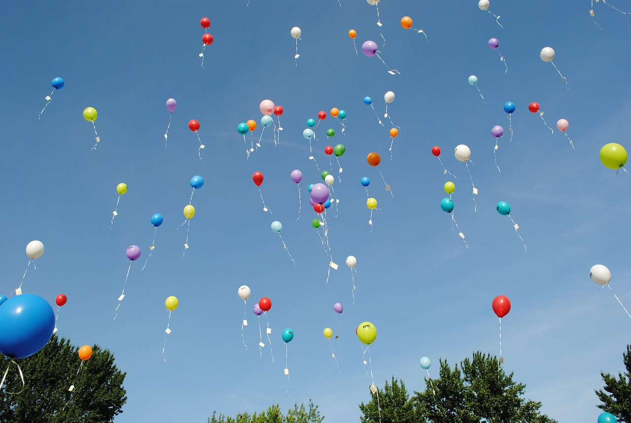 Globos de colores elevándose en el cielo azul, simbolizando ideas, emociones y experiencias que se venden como aire.